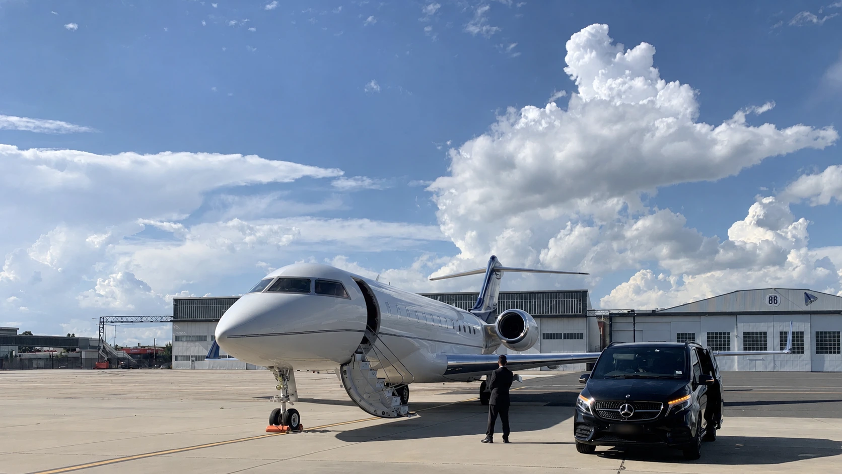 LimoStar Mercedes-Benz V-Class and chauffeur positioned beside a private jet for an airside pickup